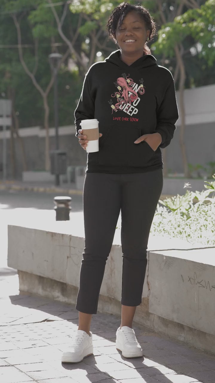 Woman in the In Too Deep hoodie drinking coffee on the street